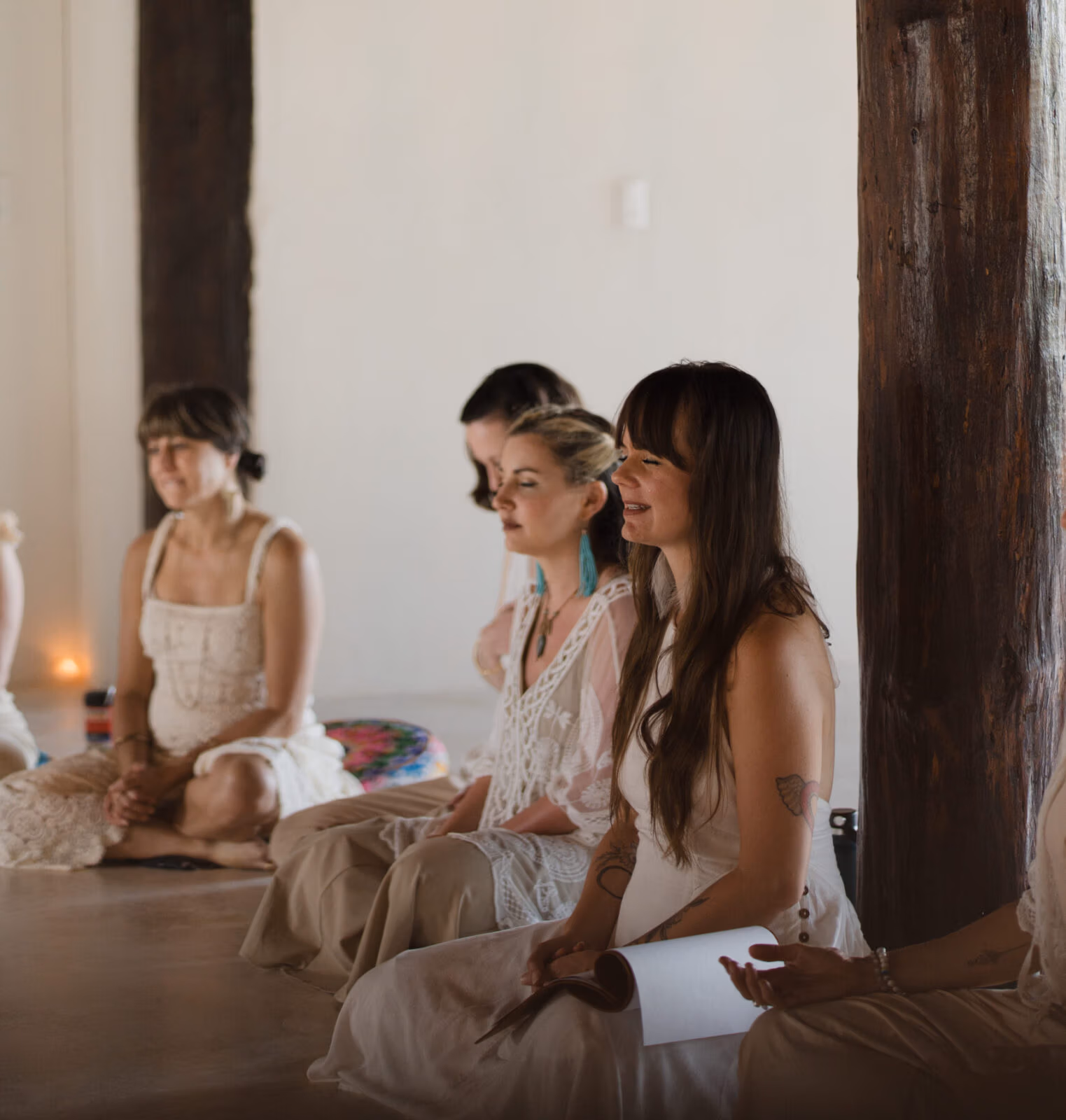 Group of women sitting in meditation and conversation during a spiritual gathering, dressed in light, flowing clothing lead by Briana Borten